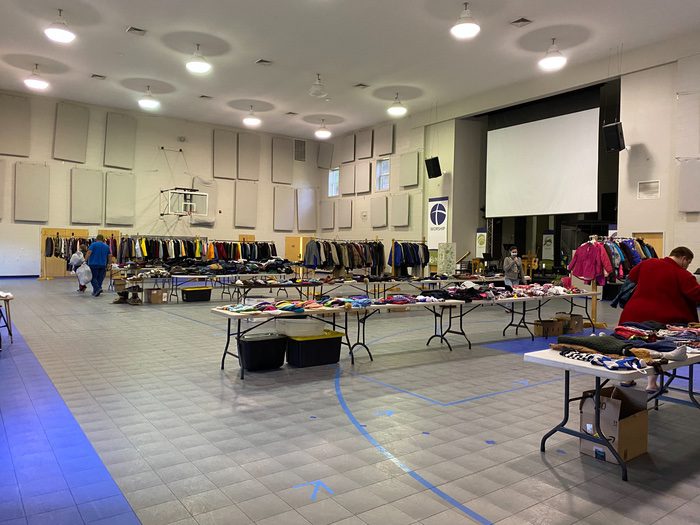 A room filled with tables and chairs covered in clothes.