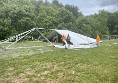 A group of people standing around a tent.