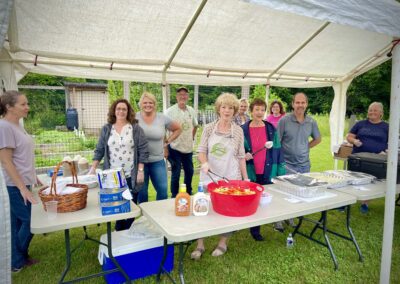 Community volunteers serving food under white canopy
