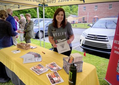 A woman standing next to a yellow table.