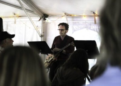 A man playing guitar in front of an audience.