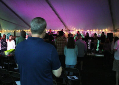 Audience watching band under purple-lit event tent