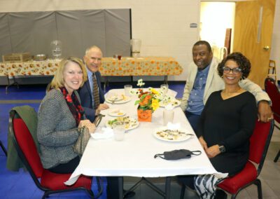 A group of people sitting at a table with food.
