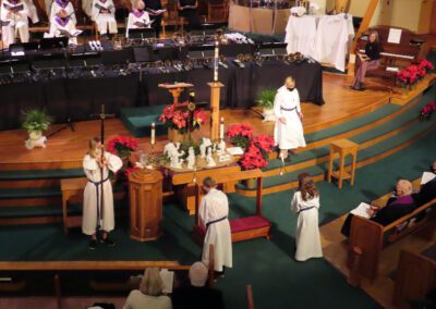 A group of people in white robes standing around a church.