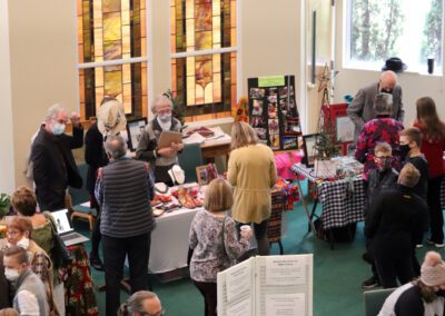 A group of people standing around tables with books.