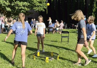 Teens playing Spikeball game on grassy lawn