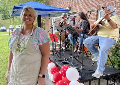 Smiling vendor in apron beside live band