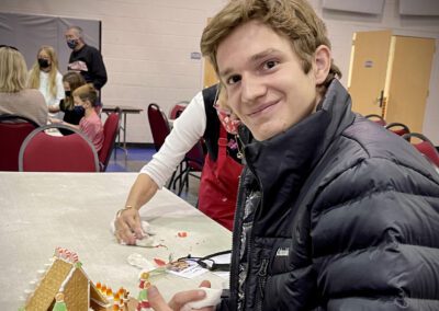 Smiling person crafting gingerbread house