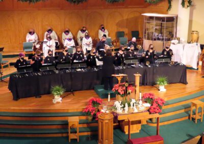 A group of people in choir robes sitting at the altar.
