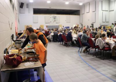A group of people standing around tables with food.