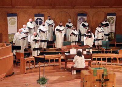 A choir of men in white robes singing.