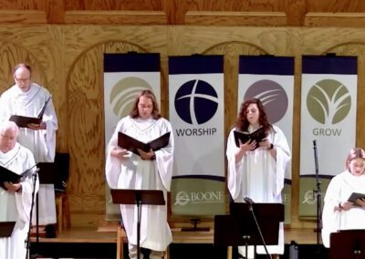 White robed church choir singing with banners