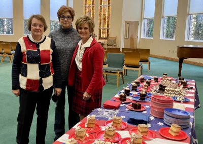 Three women posing by patriotic dessert table