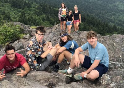 A group of people sitting on top of a mountain.