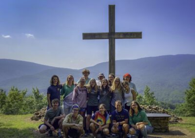 A group of people standing around a cross.